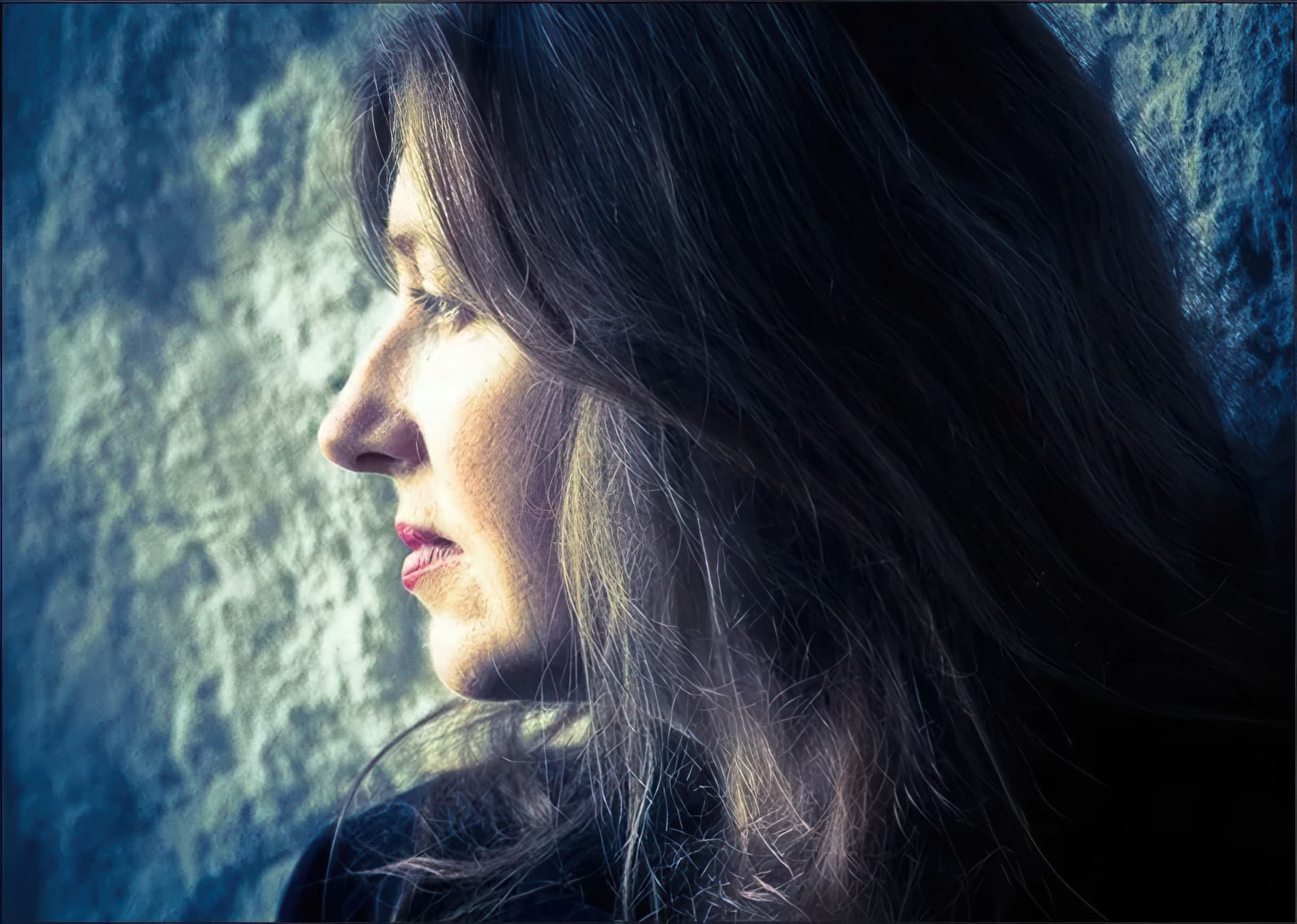 Moya O'Dwyer in profile beside a softly lit stone wall